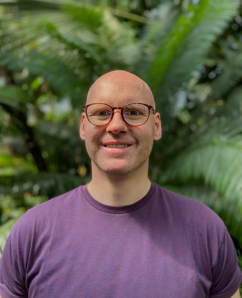 Headshot of Justinas Brazauskas, smiling, wearing glasses